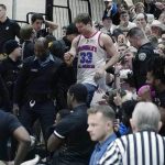 
              Police remove a fan from the stands after an altercation stopped play during the second half of the Northeast Conference men's NCAA college basketball championship game between Bryant and Wagner, Tuesday, March 8, 2022, in Smithfield, R.I. (AP Photo/Charles Krupa)
            