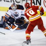 
              Edmonton Oilers goalie Mike Smith, left, lets in a goal from Calgary Flames' Matthew Tkachuk during the second period of an NHL hockey game Saturday, March 26, 2022, in Calgary, Alberta. (Jeff McIntosh/The Canadian Press via AP)
            