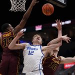 
              Drake's Tucker Devries, center, heads to the basket as Loyola of Chicago's Marquise Kennedy, left, and Tom Welch (10) defend during the first half of an NCAA college basketball game in the championship of the Missouri Valley Conference tournament Sunday, March 6, 2022, in St. Louis. (AP Photo/Jeff Roberson)
            