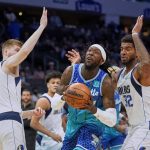 
              Charlotte Hornets center Montrezl Harrell, center, drives into the lane between Dallas Mavericks forwards Davis Bertans, left, and Marquese Chriss, right, during the first half of an NBA basketball game Saturday, March 19, 2022, in Charlotte, N.C. (AP Photo/Rusty Jones)
            