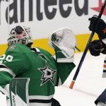 
              Dallas Stars goaltender Jake Oettinger (29) plays the puck off his mask next to Edmonton Oilers center Devin Shore (14) during the second period of an NHL hockey game in Dallas, Tuesday, March 22, 2022. (AP Photo/LM Otero)
            