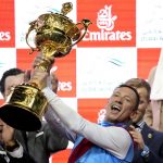 
              Lanfraco Dettori, rider of Country Grammer holds the trophy after he won the Group 1 Dubai World Cup over 2000m (10 furlongs) at Meydan Racecourse in Dubai, United Arab Emirates, Saturday, March 26, 2022. (AP Photo/Ebrahim Noroozi)
            