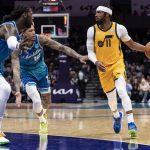 
              Utah Jazz guard Mike Conley (11) is defended by Charlotte Hornets guard Kelly Oubre Jr. (12) and center Montrezl Harrell (8) during the first half of an NBA basketball game Friday, March 25, 2022, in Charlotte, N.C. (AP Photo/Matt Kelley)
            