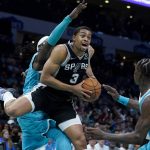 
              San Antonio Spurs forward Keldon Johnson drives to the basket between Charlotte Hornets center Montrezl Harrell and guard Terry Rozier during the second half of an NBA basketball game on Saturday, March 5, 2022, in Charlotte, N.C. (AP Photo/Chris Carlson)
            