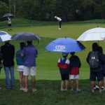 
              Golf fans braves the rain to watch Xander Schauffele putt on the ninth hole during the first round of play in The Players Championship golf tournament Friday, March 11, 2022, in Ponte Vedra Beach, Fla. (AP Photo/Lynne Sladky)
            