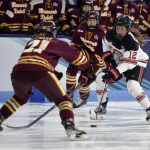 
              Ohio State's Jennifer Gardiner (12) advances the puck past Minnesota-Duluth's Taylor Stewart (21) during the first period of the NCAA Frozen Four championship hockey game, Sunday, March 20, 2022, in State College, Pa. (AP Photo/Gary M. Baranec)
            