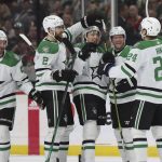 
              Dallas Stars left wing Jason Robertson, center, is surrounded by teammates in celebration after scoring a goal against the Minnesota Wild during the second period of an NHL hockey game, Sunday, March 6, 2022, in St. Paul, Minn. (AP Photo/Stacy Bengs)
            