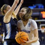 
              BYU guard Shaylee Gonzales, right, runs into the defense of Villanova guard Lucy Olsen during the second half of a college basketball game in the first round of the NCAA tournament, Saturday, March 19, 2022, in Ann Arbor, Mich. (AP Photo/Carlos Osorio)
            