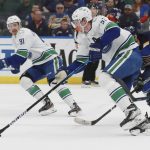 
              Vancouver Canucks' Tyler Myers (57) advances the puck during the second period of an NHL hockey game against St. Louis Blues, Monday, March 28, 2022, in St. Louis. (AP Photo/Michael Thomas)
            