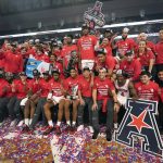 
              Houston players and staff pose for photos after defeating Memphis in an NCAA college basketball game for the American Athletic Conference tournament championship in Fort Worth, Texas, Sunday, March 13, 2022. (AP Photo/LM Otero)
            