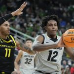 
              Colorado's Jabari Walker (12) passes around Oregon's Rivaldo Soares (11) during the second half of an NCAA college basketball game in the quarterfinal round of the Pac-12 tournament Thursday, March 10, 2022, in Las Vegas. (AP Photo/John Locher)
            