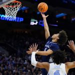 
              St. Peter's Daryl Banks III, top, goes up for a shot against North Carolina's R.J. Davis during the first half of a college basketball game in the Elite 8 round of the NCAA tournament, Sunday, March 27, 2022, in Philadelphia. (AP Photo/Matt Rourke)
            