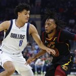 
              Cleveland Cavaliers guard Darius Garland (10) drives against Dallas Mavericks guard Josh Green (8) during the first half of an NBA basketball game Wednesday, March 30, 2022, in Cleveland. (AP Photo/Ron Schwane)
            