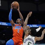 
              Oklahoma City Thunder guard Shai Gilgeous-Alexander (2) goes to the basket in front of Utah Jazz forward Royce O'Neale, rear, and guard Nickeil Alexander-Walker (6) in the first half of an NBA basketball game Sunday, March 6, 2022, in Oklahoma City. (AP Photo/Sue Ogrocki)
            