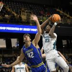 
              UNC Wilmington forward Amari Kelly (23) goes to the basket against Delaware forward Dylan Painter (42) during the first half of an NCAA college basketball game in the championship of the Colonial Athletic Association conference tournament, Tuesday, March 8, 2022, in Washington. (AP Photo/Nick Wass)
            