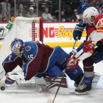 
              Colorado Avalanche goaltender Darcy Kuemper, left, covers the puck as Avalanche defenseman Devon Toews, back right, slows down Calgary Flames center Elias Lindholm (28) in the second period of an NHL hockey game Sunday, March 13, 2022, in Denver. (AP Photo/David Zalubowski)
            