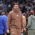 
              Dallas Mavericks guard Luka Doncic wears sweats on the floor during a time out in the first quarter of an NBA basketball game against the Houston Rockets in Dallas, Wednesday, March 23, 2022. Doncic took the night off to rest. (AP Photo/LM Otero)
            