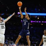 
              Saint Peter's Daryl Banks III, center, goes up for a shot against Purdue's Ethan Morton, left, Jaden Ivey during the second half of a college basketball game in the Sweet 16 round of the NCAA tournament, Friday, March 25, 2022, in Philadelphia. (AP Photo/Chris Szagola)
            