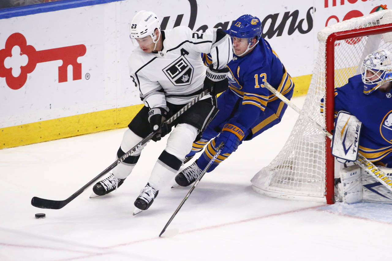 Los Angeles Kings right wing Dustin Brown (23) carries the puck past Buffalo Sabres defenseman Mark...