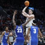 
              Gonzaga forward Drew Timme, top, puts up a shot above Memphis center Malcolm Dandridge (23) and guard Landers Nolley II (3) during the second half of a second-round NCAA college basketball tournament game, Saturday, March 19, 2022, in Portland, Ore. (AP Photo/Craig Mitchelldyer)
            