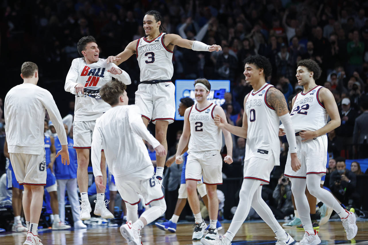 Gonzaga guard Andrew Nembhard (3) and forward Drew Timme (2) react with teammates after they beat M...