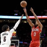
              New Orleans Pelicans guard CJ McCollum, right, hits a shot over Portland Trail Blazers guard Keon Johnson during the first half of an NBA basketball game in Portland, Ore., Wednesday, March 30, 2022. (AP Photo/Steve Dykes)
            