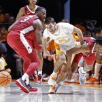
              Arkansas guard Stanley Umude (0) collides with Tennessee guard Santiago Vescovi (25) as they battle for the ball during the first half of an NCAA college basketball game Saturday, March 5, 2022, in Knoxville, Tenn. (AP Photo/Wade Payne)
            