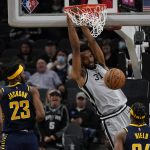 
              San Antonio Spurs' Keita Bates-Diop (31) dunks against Indiana Pacers' Isaiah Jackson (23) and Buddy Hield (24) during the first half of an NBA basketball game in San Antonio, Saturday, March 12, 2022. (AP Photo/Chuck Burton)
            