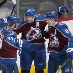 
              Colorado Avalanche center Nathan MacKinnon, center, is congratulated after scoring the winning goal by left wing J.T. Compher, left, and defenseman Cale Makar in overtime of an NHL hockey game against the Edmonton Oilers Monday, March 21, 2022, in Denver. (AP Photo/David Zalubowski)
            