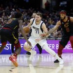 
              Dallas Mavericks guard Luka Doncic (77) drives against Cleveland Cavaliers forward Lamar Stevens (8) and guard Caris LeVert (3) during the second half of an NBA basketball game Wednesday, March 30, 2022, in Cleveland. (AP Photo/Ron Schwane)
            