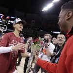 
              Stanford guard Anna Wilson, left, gets flowers from her brother, NFL football Denver Broncos quarterback Russell Wilson after a college basketball game against Texas in the Elite 8 round of the NCAA tournament, Sunday, March 27, 2022, in Spokane, Wash. Stanford won 59-50. (AP Photo/Young Kwak)
            