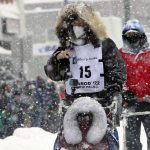 
              Riley Dyche, a musher from Fairbanks, Alaska, takes his sled dogs through a snowstorm in downtown Anchorage, Alaska, on Saturday, March 5, 2022, during the ceremonial start of the Iditarod Trail Sled Dog Race. The competitive start of the nearly 1,000-mile race will be held March 6, 2022, in Willow, Alaska, with the winner expected in the Bering Sea coastal town of Nome about nine days later. (AP Photo/Mark Thiessen)
            