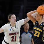 
              Louisville forward Emily Engstler (21) defends Michigan forward Emily Kiser (33) during the first half of a college basketball game in the Elite 8 round of the NCAA women's tournament Monday, March 28, 2022, in Wichita, Kan. (AP Photo/Jeff Roberson)
            