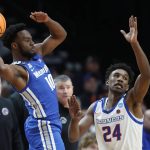 
              Memphis guard Alex Lomax, left, looks to pass over Boise State forward Abu Kigab (24) during the first half of a first round NCAA college basketball tournament game, Thursday, March 17, 2022, in Portland, Ore. (AP Photo/Craig Mitchelldyer)
            