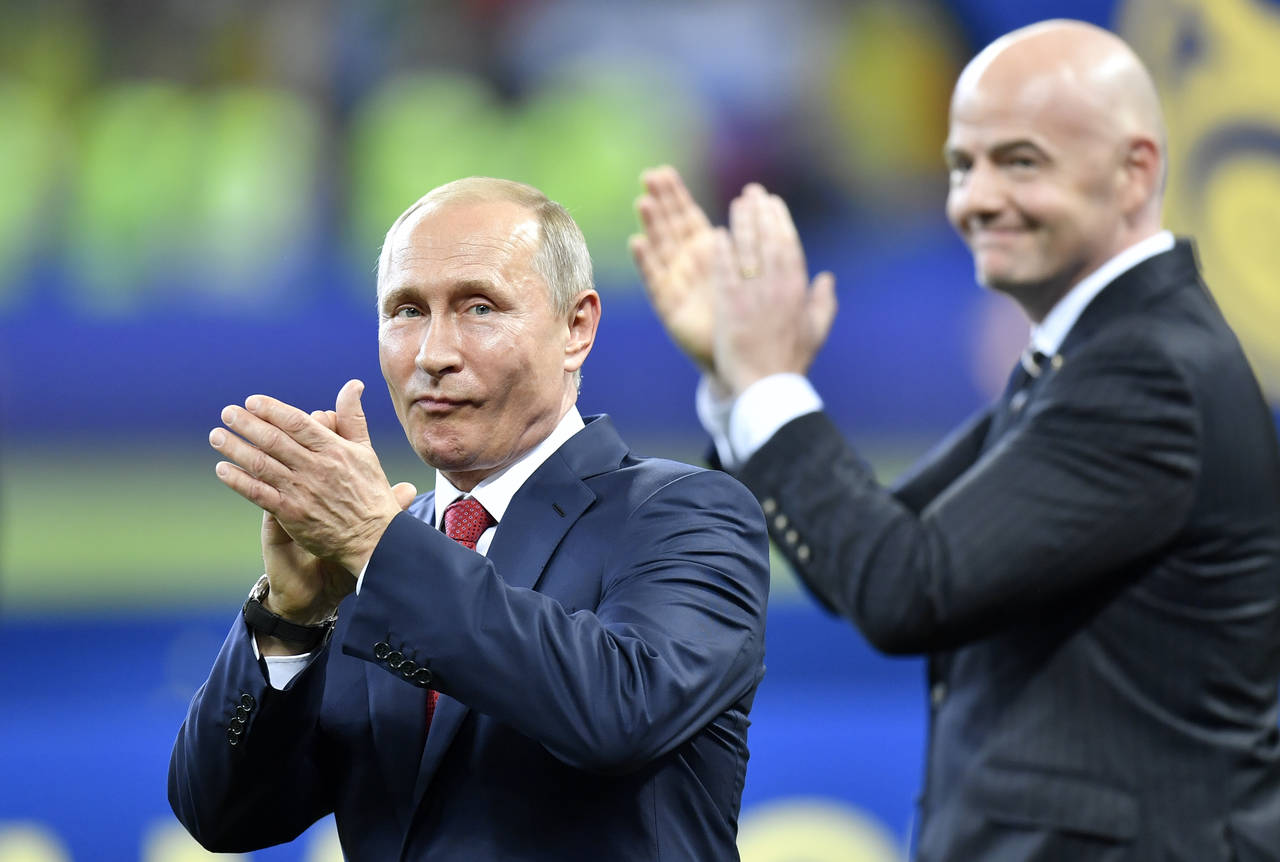 FILE - Russian President Vladimir Putin, left, applauds beside FIFA President Gianni Infantino at t...