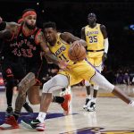 
              Los Angeles Lakers' Malik Monk (11) is pressured by Toronto Raptors' Gary Trent Jr. (33) during first half of an NBA basketball game Monday, March 14, 2022, in Los Angeles. (AP Photo/Jae C. Hong)
            
