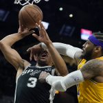 
              San Antonio Spurs forward Keldon Johnson (3) is fouled by Los Angeles Lakers forward Carmelo Anthony (7) as he drives to the basket during the second half of an NBA basketball game, Monday, March 7, 2022, in San Antonio. (AP Photo/Eric Gay)
            