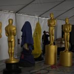 
              Oscar statues sit in a tent during preparations for Sunday's 94th Academy Awards outside the Dolby Theatre on Friday, March 25, 2022, in Los Angeles. (AP Photo/John Locher)
            