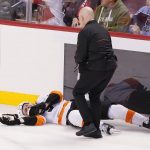 
              A member of Philadelphia Flyers team approaches center Scott Laughton, who lies on the ice after he was injured during the second period of the team's NHL hockey game against the Florida Panthers, Thursday, March 10, 2022, in Sunrise, Fla. (AP Photo/Marta Lavandier)
            