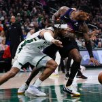 
              Milwaukee Bucks' DeAndre' Bembry and Phoenix Suns' Torrey Craig go after a loose ball during the first half of an NBA basketball game Sunday, March 6, 2022, in Milwaukee . (AP Photo/Morry Gash)
            