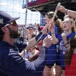 
              Atlanta Braves shortstop Dansby Swanson hands a souvenir back to a fan as he signs autographs prior to the start a spring training baseball game against the Toronto Blue Jays at CoolToday Park Monday March 28, 2022, in North Port, Fla. (AP Photo/Steve Helber)
            