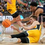 
              Iowa's Jordan Bohannon, bottom, passes the ball away from Richmond's Jacob Gilyard in the first half of a college basketball game during the first round of the NCAA men's tournament Thursday, March 17, 2022, in Buffalo, N.Y. (AP Photo/Frank Franklin II)
            