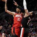
              Houston Rockets center Christian Wood, left, passes the ball as Portland Trail Blazers forward Trendon Watford, right, defends during the first half of an NBA basketball game in Portland, Ore., Saturday, March 26, 2022.(AP Photo/Steve Dykes)
            