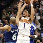 
              Phoenix Suns guard Devin Booker shoots as Minnesota Timberwolves guard Jordan McLaughlin (6) and forward Anthony Edwards, right, defend during the first half of an NBA basketball game Wednesday, March 23, 2022, in Minneapolis. (AP Photo/Andy Clayton-King)
            