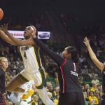 
              Baylor center Queen Egbo (4) drives for a layup past Texas Tech center Ella Tofaeono (1) and guard Lexy Hightower (4) during the first half of an NCAA college basketball game in Waco, Texas, Sunday, March 6, 2022. (AP Photo/LM Otero)
            