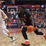 
              Miami guard Bensley Joseph, right, drives to the basket against Syracuse guard Buddy Boeheim during the first half of an NCAA college basketball game in Syracuse, N.Y., Saturday, March 5, 2022. (AP Photo/Adrian Kraus)
            