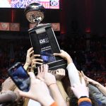 
              Illinois fans and players hold up the Big Ten Championship trophy at the conclusion of an NCAA college basketball game against Iowa, Sunday, March 6, 2022, in Champaign, Ill. (AP Photo/Michael Allio)
            