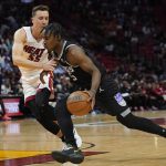 
              Sacramento Kings guard Davion Mitchell, right, dribbles around Miami Heat guard Duncan Robinson, left, during the first half of an NBA basketball game, Monday, March 28, 2022, in Miami. (AP Photo/Marta Lavandier)
            