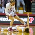 
              Indiana guard Ali Patberg (14) celebrates on the floor with guard Nicole Cardano-Hillary (4) after being fouled on a shot by Princeton in the first half of a college basketball game in the second round of the NCAA tournament in Bloomington, Ind., Monday, March 21, 2022. (AP Photo/Michael Conroy)
            