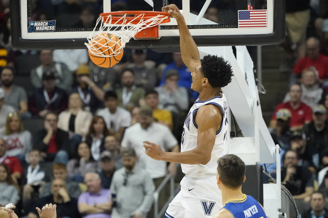 Villanova's Jermaine Samuels, top, dunks past Delaware's Dylan Painter during the first half of a c...